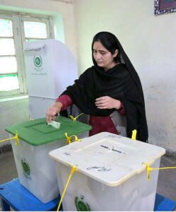 Women showing their identity card while standing in queue to cast their vote in polling station during General Election-2024