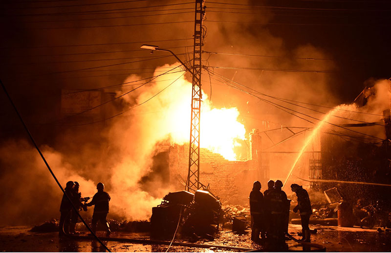 Firefighters struggling to extinguish fire that erupts after a cylinder blast cylinder storeroom resulting in one person injured in this incident at Akbari Mandi