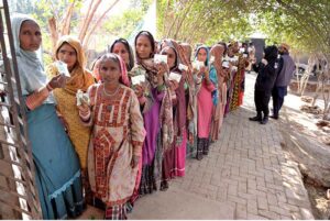Women voters showing identity cards while standing in queue waiting for their turn to cast vote in polling station during General Election-2024