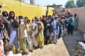 Women voters showing identity cards while standing in queue waiting for their turn to cast vote in polling station during General Election-2024