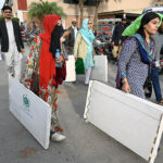 Election presiding officers on their way after collecting ballot materials at a distribution center at Expo Center a day prior Pakistan’s General Elections-2024.
