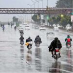 Motorcyclists and vehicles on their way at Islamabad Expressway during rain that experienced the Federal Capital