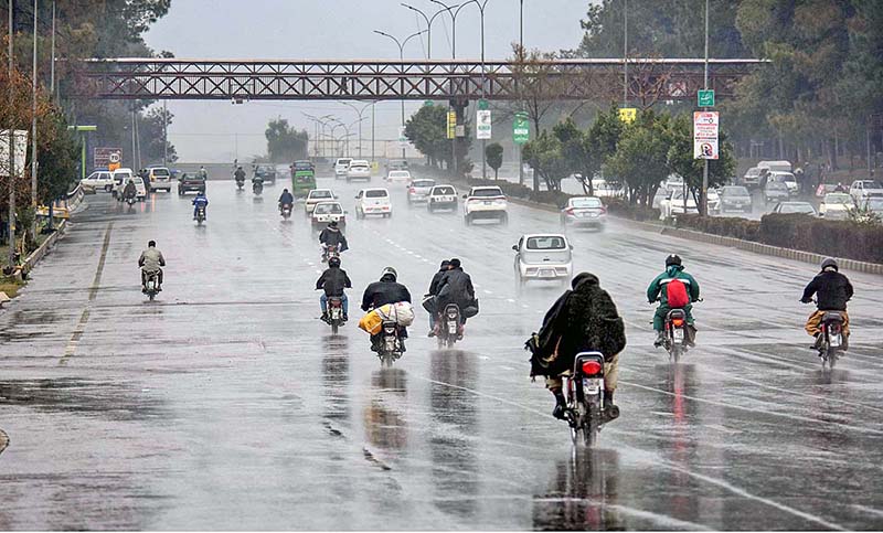 Motorcyclists and vehicles on their way at Islamabad Expressway during rain that experienced the Federal Capital
