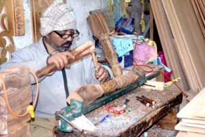  A carpenter making wooden furniture at his setup on Said Pur Road.