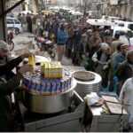 A large number of people standing in a queue to get free iftaar during Holy fasting Month of Ramadan at Jamia Masjid Road