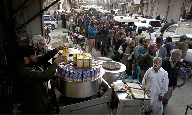 A large number of people standing in a queue to get free iftaar during Holy fasting Month of Ramadan at Jamia Masjid Road