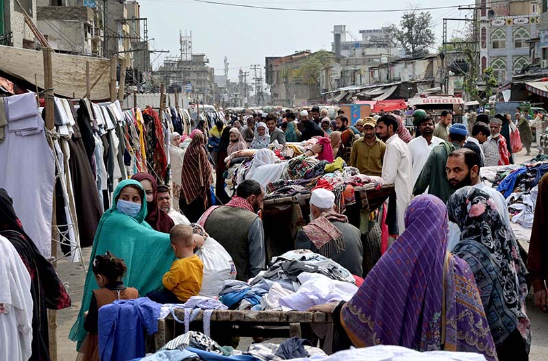 People selecting and purchasing second-hand clothes from vendor at Ganj Mandi Road at Raja Bazaar in the city.