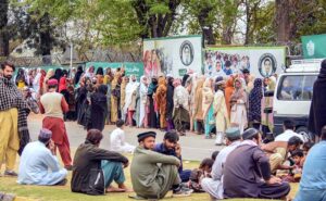 Women queueing up outside Benazir income support centre to receive cash money at Sitara Market.