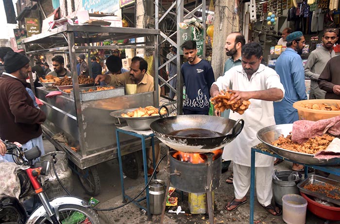 Vendors busy frying and displaying traditional food item (Pakora,Samosa) for Iftar during Holy Fasting Month of Ramadan.