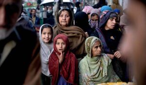 A large number of people standing in a queue to get free iftaar during Holy fasting Month of Ramadan at Jamia Masjid Road