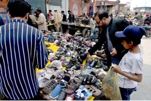 People selecting and purchasing second-hand clothes from vendor at Ganj Mandi Road at Raja Bazaar in the city.