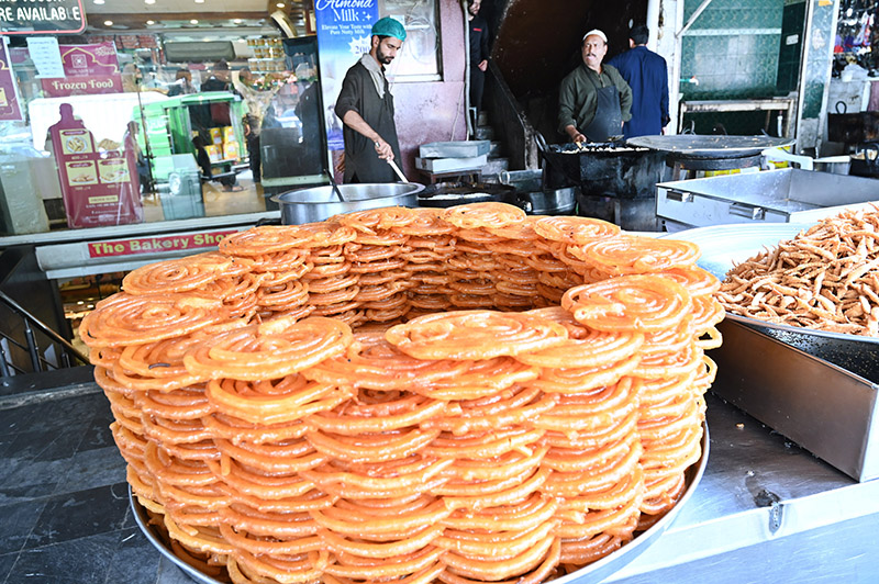 A vendor prepares sweet food item Jalebi at his roadside setup in Karachi Company Market