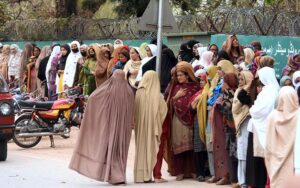 Women queueing up outside Benazir income support centre to receive cash money at Sitara Market.