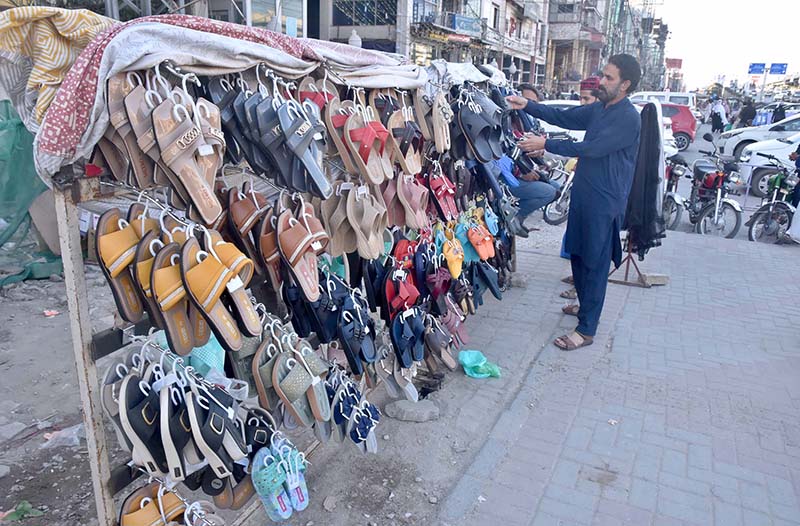 A vendor displaying shoes at his roadside setup on Murree Road.
