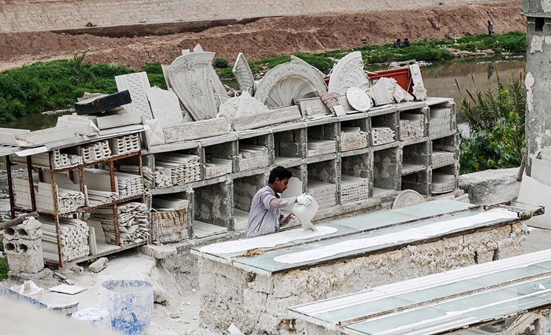 A labourer preparing ceiling material at his workplace at Lehtrar Road.