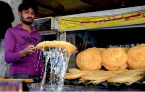 A vendor preparing traditional food item Pheoni in connection with upcoming Holy Fasting Month of Ramadan at Banni Chowk