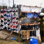 A street vendor arranging and displaying face masks at roadside