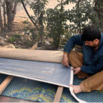 Worker busy sewing traditional curtain (Chik) at his roadside setup in the city