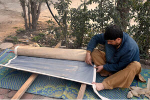 Worker busy sewing traditional curtain (Chik) at his roadside setup in the city