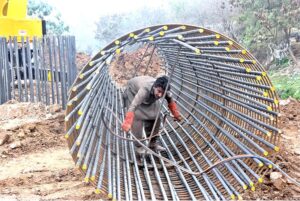A labourer fixing Iron bars to make frame for pillar of a bridge on IJP Road during development work in the city