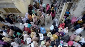 Women gather outside the Ration distribution center organized by Tehreem Quran Academy.