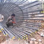 A labourer fixing Iron bars to make frame for pillar of a bridge on IJP Road during development work in the city