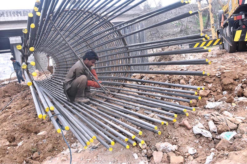 A labourer fixing Iron bars to make frame for pillar of a bridge on IJP Road during development work in the city