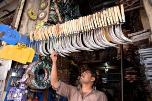 A vendor displays to sell sickles at his shop as wheat cutting season round the corner at Muslim Bazar.