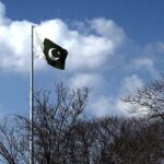 A beautiful view of national flag flying as in the background an attractive view of clouds hovering over the skies of Federal Capital.