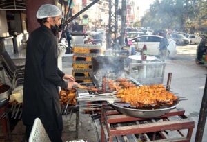 A Vendor preparing barbeque at roadside in the city