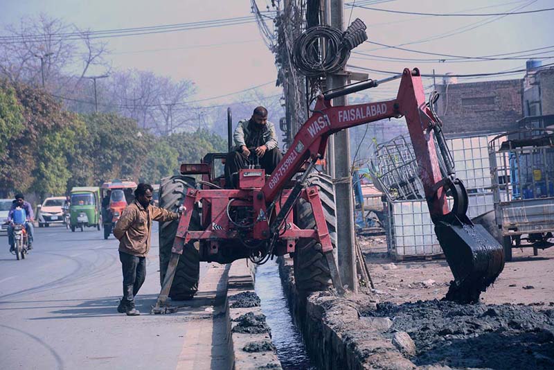 WASA workers are removing silt from a sewerage channel at Sammundri Road to ensure implementation on "Suthra Punjab" program.