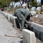 Labourer busy in construction work of footpath at Club Road