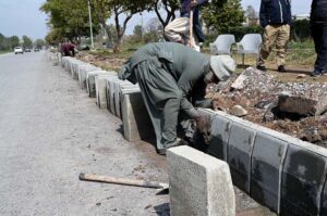 Labourer busy in construction work of footpath at Club Road