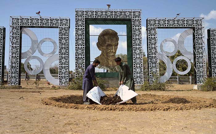 CDA gardeners spreading fertilizer for planting saplings at roadside greenbelt in Federal Capital.