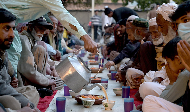Volunteers serving iftar for deserving people at Eidgah Sharif.