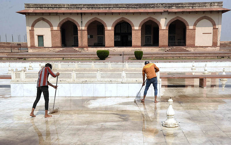 Workers cleaning floor at Lahore Fort