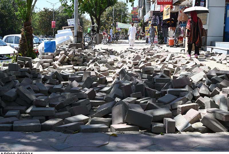 New tuff tiles being installed on the footpath at Aabpara market.