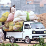 Workers tying up bags of husk onto a Suzuki Van at Pirwadhai