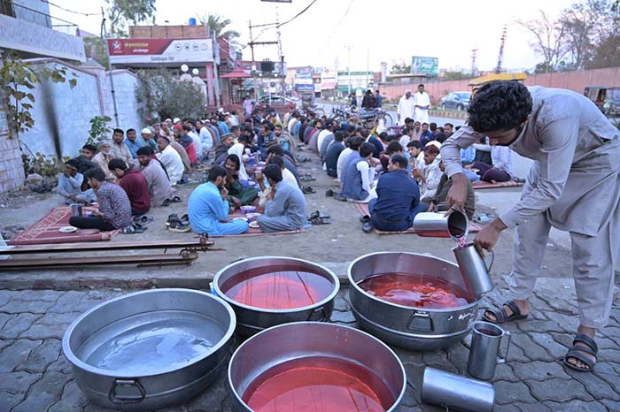 Volunteers of Imran Motors preparing sweet drinks for Iftar at Khayam Chowk.