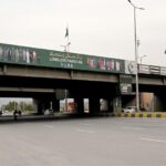 NATIONAL flags flutter cover a billboard installed on Faizabad Bridge ahead of Pakistan day on 23 March 2024