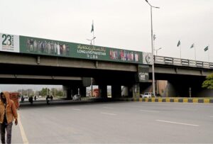 NATIONAL flags flutter cover a billboard installed on Faizabad Bridge ahead of Pakistan day on 23 March 2024
