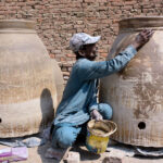 A worker busy giving final touch to clay made traditional oven (Tandoor) at his workplace