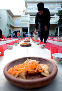 Volunteers serving iftar for deserving people at Eidgah Sharif.