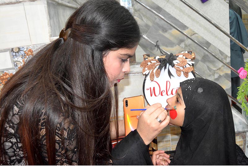 A position holder student getting paint on face on the Annual Result Day at a private school.