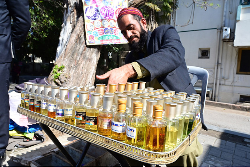 A vendor is displaying different perfumes to attract the customers at his roadside setup during Holy month of Ramzan in Federal Capital.