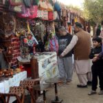 A vendor displaying clay-made and wooden items to attract customers at his setup in the city