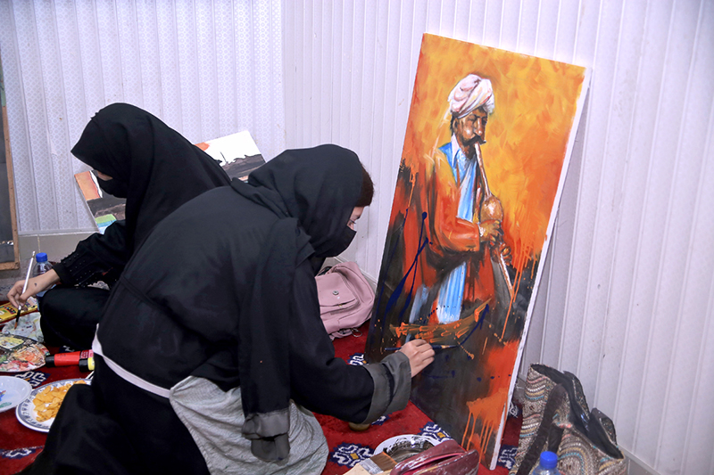Student giving final touch to painting during Punjab painting competitions organized by Sargodha Arts Council