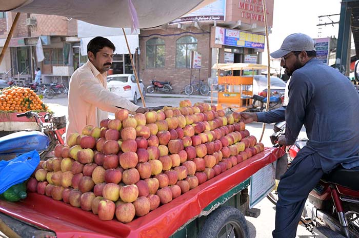 A vendor selling apple to attract customers at Noori gate.