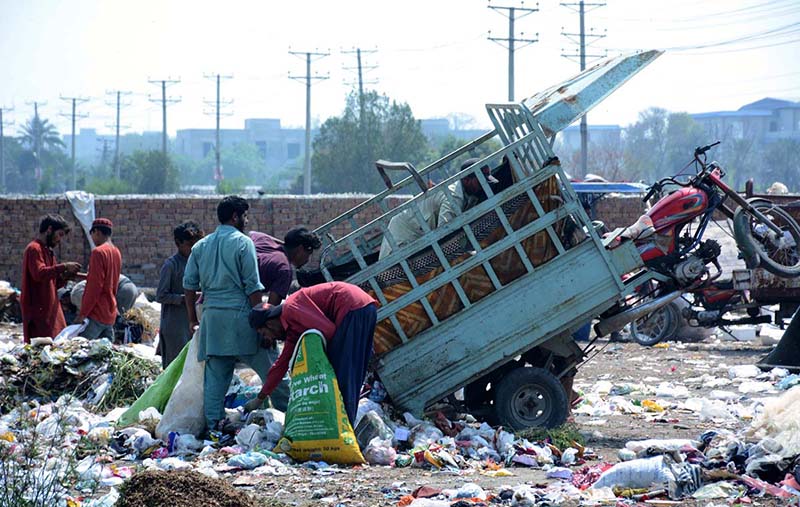 Gypsy youngsters searching and collecting recycle items from heap of garbage.