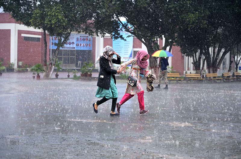 Students on the way at University of Sargodha during rain that experienced the city